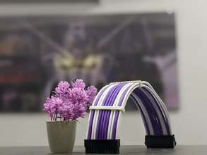 Purple and white cable management product with a potted plant and blurred background