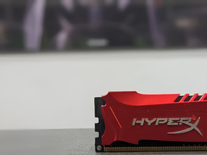 Red HyperX RAM stick on a blurred background