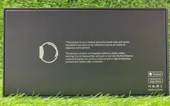 Black electronic device packaging with text and a logo on grass