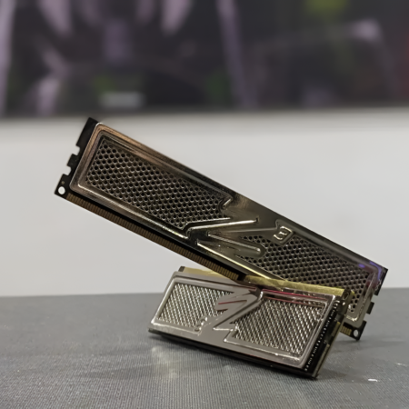 Metallic computer memory module on a reflective surface with a blurred background