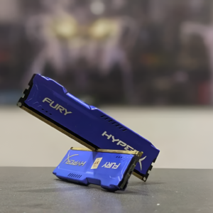 Blue HyperX FURY RAM sticks on a gray surface with a blurred background
