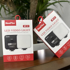 Two NeePro LED video lights in their packaging on a wooden surface with a plant in the background.