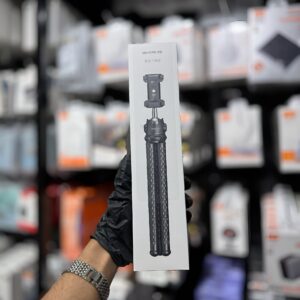 Hand holding a box with a tripod on a blurred store shelf background